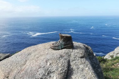 Finisterra 'da, burunda, deniz kenarında bronz çizme. Camino de Santiago