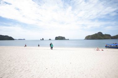 İnsanlar sahilde yürüyor.