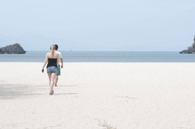 İnsanlar sahilde yürüyor.