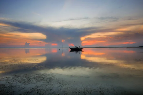 balıkçı teknesi ile dramatik gün batımı görünümü. uzun pozlama