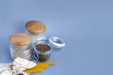 Sıfır atık konsepti ev tarzı, yemek pişirme. Mavi arka planda cam kavanozlar ve metin için kopyalama alanı. Çevre dostu ve konsepti yeniden kullan. Biyolojik organik gıda..