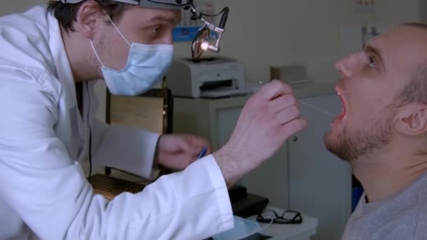 Jovem Otorrinolaringologista Examinando Paciente Masculino Sua Clínica — Vídeo de Stock