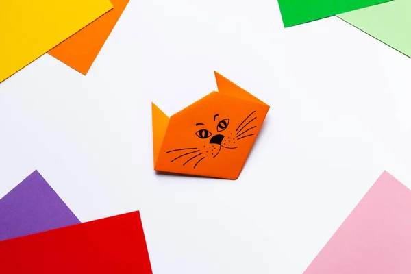 Step by step guide for children how to make an origami cat. Step 7 of 7. Ideas for family leisure time during quarantine. Fine motor skills, creativity development and fun. Flat lay top view