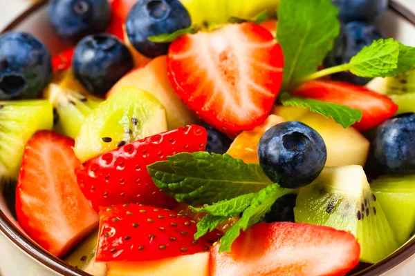 Concept of low calories delicious desserts. Summer fresh bowl with colorful fruit salad. Healthy natural organic food. Tasty sweet snack, light simple summer lunch. Close up macro view