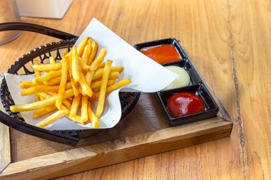 Patates kızartması soslu sepetin içinde.