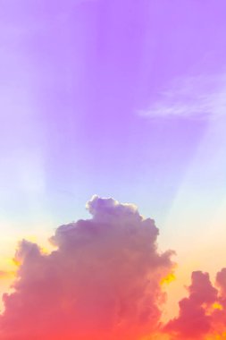 Mor gökyüzünde renkli güneş ışığı ve turuncu ışıklı kırmızı bulutlar.