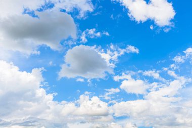 Mavi gökyüzünde beyaz bulutlarla aydınlık bir gün.