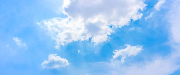 white sun light on blue sky with white clouds