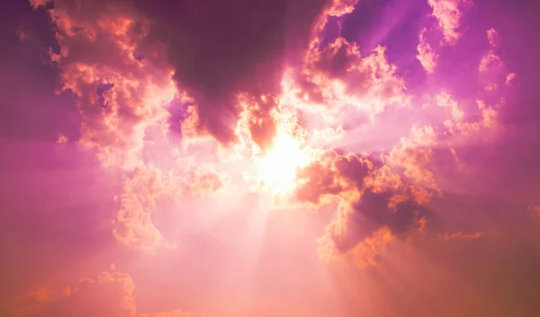 bright sun and sun beam light in purple pink sky with fluffy clouds,fantasy sky