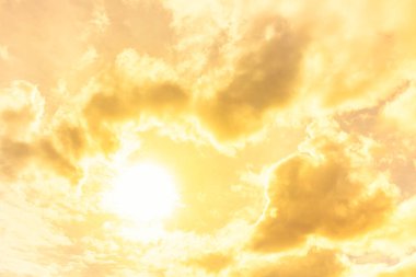 Gökyüzünde bulutlarla parlayan turuncu güneş ışığı