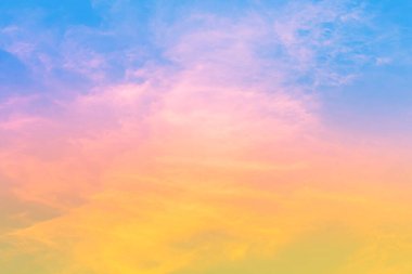 Mavi gökyüzündeki bulanık bulutlarda pembe ve turuncu sarı ışık