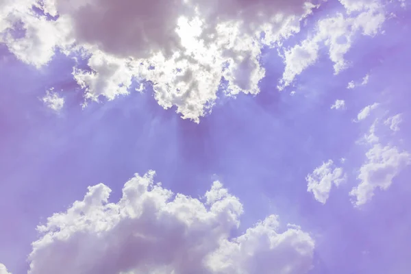 sun bright with sun beam light in purple sky with fluffy bright clouds