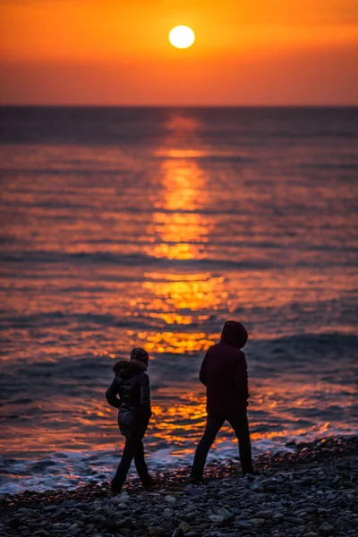 Köpüklü güzel dalgalar, denizin batan güneşiyle aydınlanıyor. Gün batımında dalgalı deniz yüzeyinin dokusu.