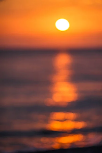 Köpüklü güzel dalgalar, denizin batan güneşiyle aydınlanıyor. Gün batımında dalgalı deniz yüzeyinin dokusu.