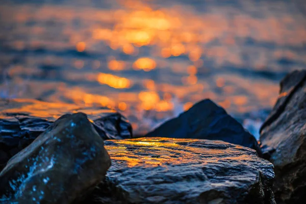 Sahildeki büyük kayalıklarda güneşten parlayan portakal.