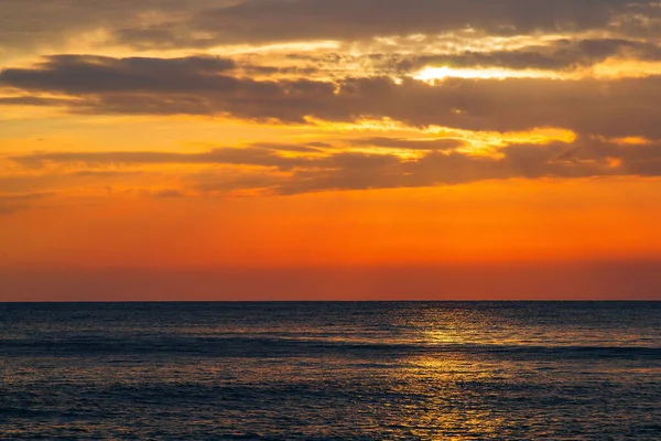 Denizde güzel bir gün batımı. Batan güneşin ışınları parlıyor