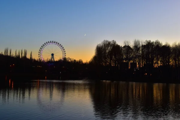 Dönme dolap manzaralı parkta gün batımı 