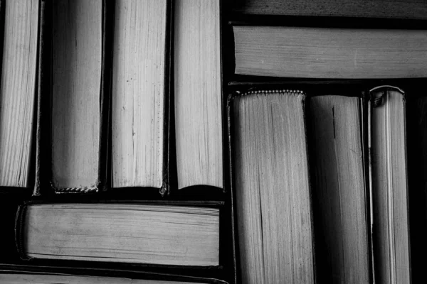 Eski kitaplar yan yana. Doku. Uzayı kopyala Siyah ve beyaz. Yukarı görünüm.