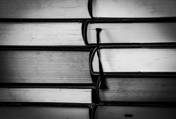 Eski kitaplar istiflenmiş. Doku. Uzayı kopyala Siyah ve beyaz.