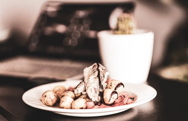 Laptop çalışma alanında öğle yemeği. Kaktüs süslemeli deniz salatası tabağı. Seçici odak