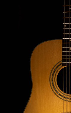 Siyah arkaplanlı akustik gitar yakın çekim görüntüsü. Seçici odaklanma. Boşluğu Kopyala.
