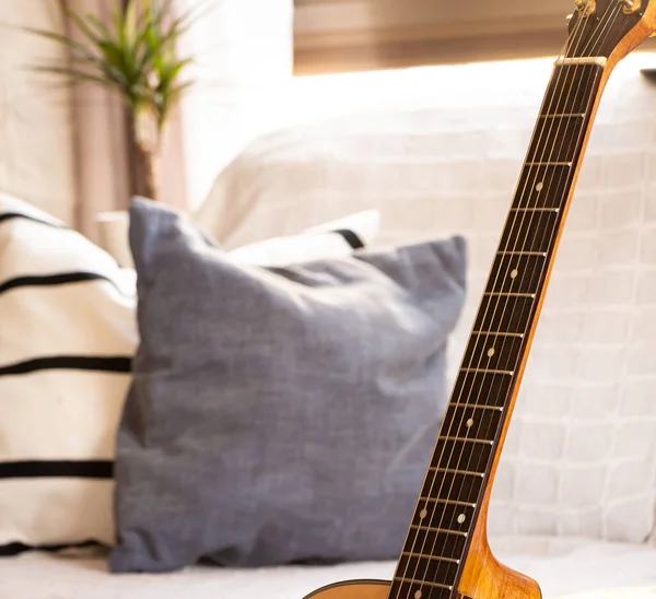Zarif bir oturma odasında akustik gitar. Seçici odak.