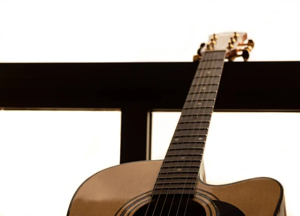 Pencerede gitar var, arka planda fazla görüntü var. Seçici odaklanma. Boşluğu kopyala.