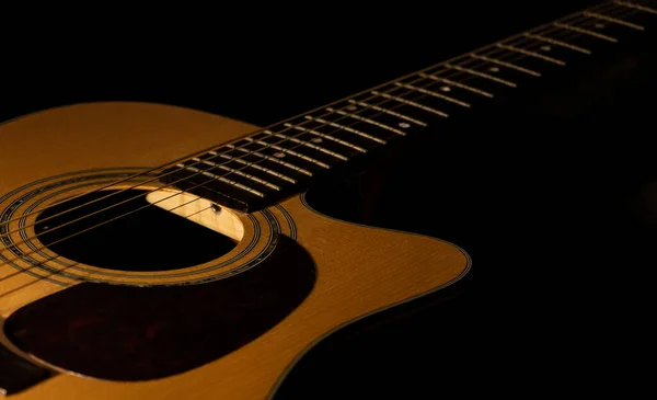 Siyah arkaplanlı akustik gitar yakın çekim görüntüsü. Seçici odak.