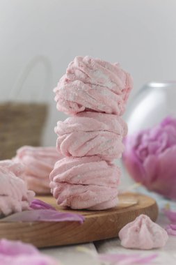 Beyaz ahşap bir masada pembe ve pembe şakayık.