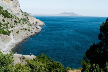 Dağ ve mavi suyla açık deniz manzarası