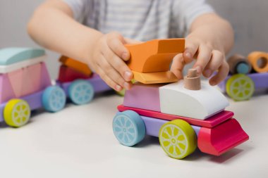 Küçük bir çocuk bir lokomotif yapımcısıyla oynuyor.