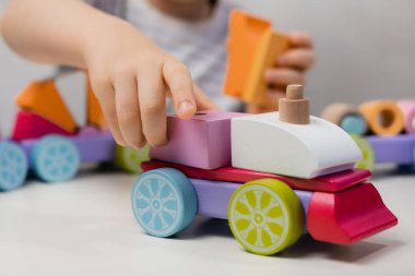 Küçük bir çocuk bir lokomotif yapımcısıyla oynuyor.