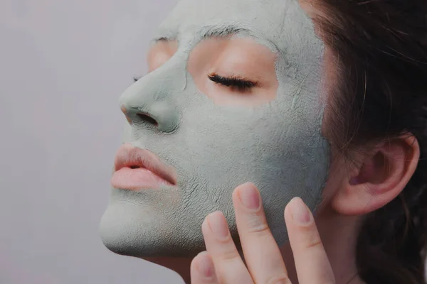 Yüzünde kozmetik maske olan genç bir kız. Yakın plan.