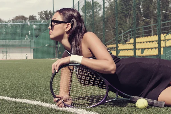 Chica se encuentra en una hierba de una cancha de tenis —  Fotos de Stock