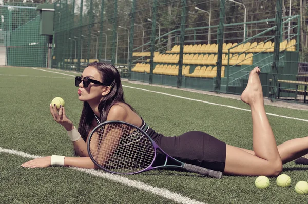 Chica se encuentra en una hierba de una cancha de tenis —  Fotos de Stock