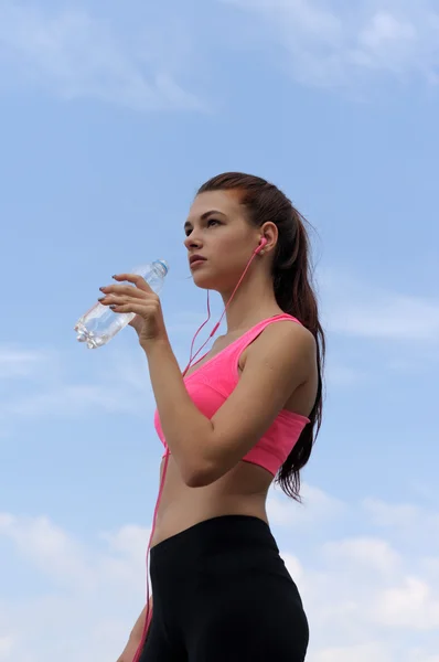 Chica bebe agua de una botella de plástico —  Fotos de Stock