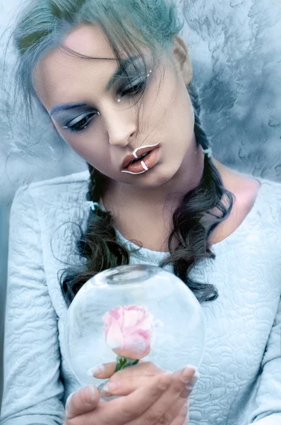 Girl holds a glass flask in the frost with a rose inside — Stock Photo, Image