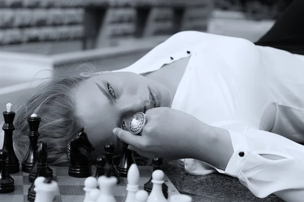 Dívka je položenou hlavu na šachovnici Royalty Free Stock Obrázky
