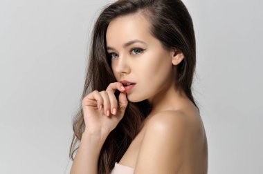 Kız dudaklarını eliyle ilgilendiriyor.