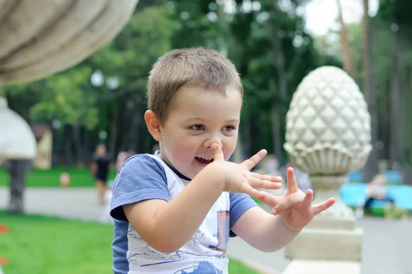 Ragazzo seduto sulla recinzione nel parco — Foto Stock