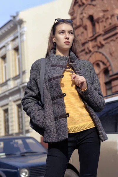 Femme à la mode dans un pull jaune-orange vif et un c gris — Photo