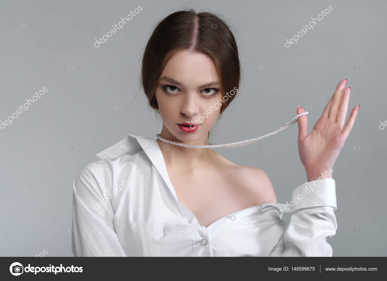 Ragazza nuda spalla tirando di perle intorno al collo Lei ha un ordinato capelli e trucco luminoso e indossa una camicia bianca — Foto di AlexShalamov