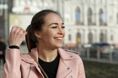 Şehirde yürüyüş sırasında neşeli kız gülüyor