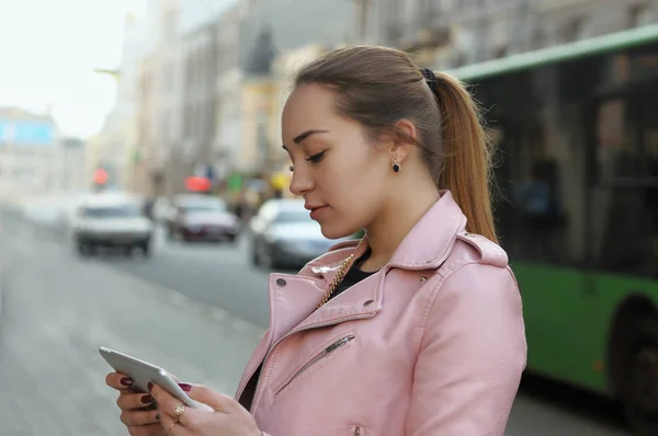 Chica utiliza la aplicación en la tableta mientras camina por la calle —  Fotos de Stock