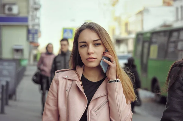 Schönes Mädchen telefoniert, während es auf dem Gehweg geht — Stockfoto