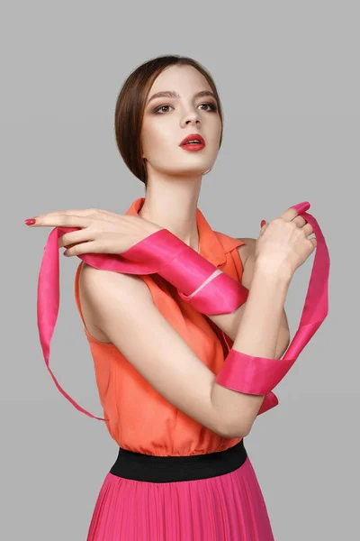 Studio fashion portrait of a beautiful girl in a pink-carrot dre — Stock Photo, Image