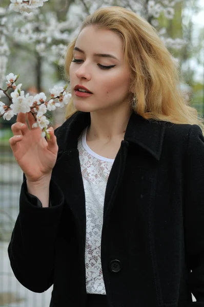 Menina gosta do cheiro de damascos floridos — Fotografia de Stock