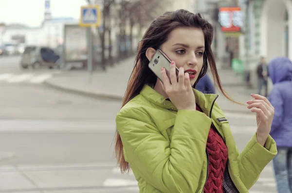 Girl is talking on the phone while walking around the city