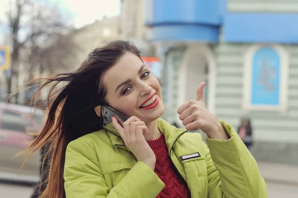 Girl is talking on the phone while walking around the city