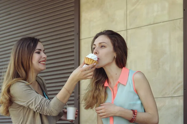 Ein Mädchen füttert ein anderes, während sie Kaffee trinken — Stockfoto